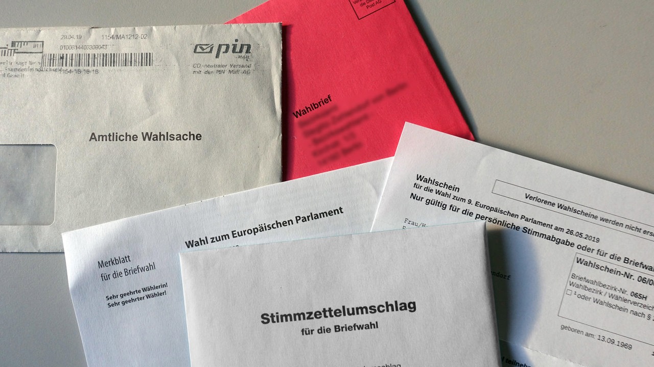 Wahlunterlagen für eine Briefwahl zum Europäischen Parlament liegen auf einem Tisch.